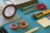 colored tape, scissors, box cutter, and post-its laid out in a grid pattern on table